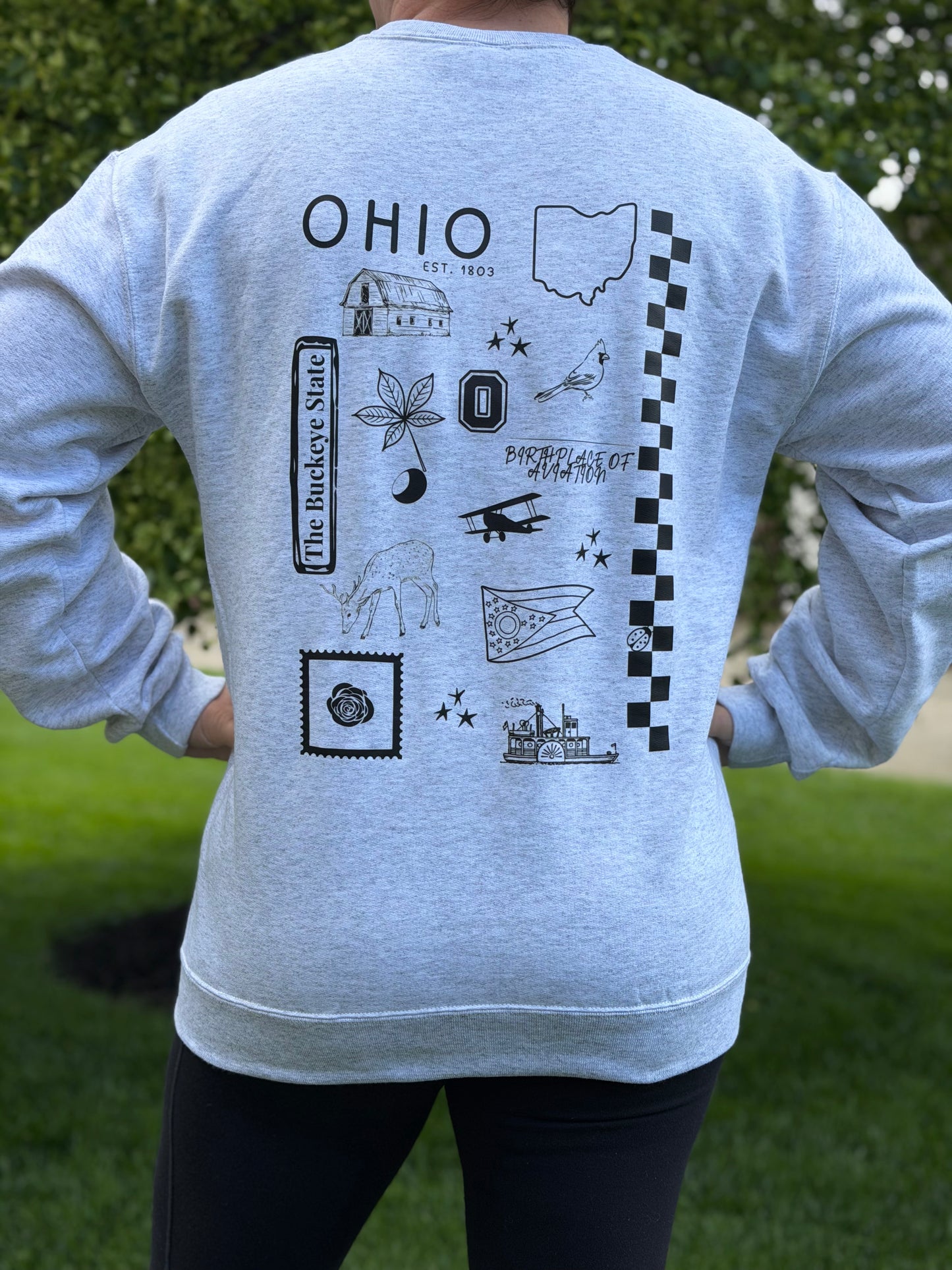 Gray sweatshirt with black state of Ohio symbols and 'OHIO' text on the back, worn by a person outdoors.