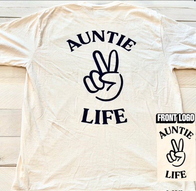 Ivory t-shirt with navy blue 'Auntie Life' text and peace sign graphic on a wooden surface