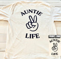 Ivory t-shirt with navy blue 'Auntie Life' text and peace sign graphic on a wooden surface