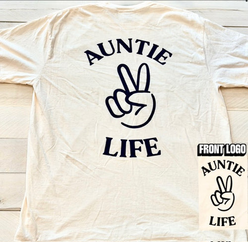 Ivory t-shirt with navy blue 'Auntie Life' text and peace sign graphic on a wooden surface